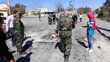 In this picture taken Friday, April 1, 2016, Syrian soldiers explain the military operation to clear Palmyra to journalists, in the ancient city of Palmyra in the central city of Homs, Syria. Explosions rocked the ancient town of Palmyra on Friday and on the horizon, black smoke wafted behind its majestic Roman ruins, as Syrian army experts carefully detonated hundreds of mines they say were planted by Islamic State militants before they fled the town. (AP Photo)
