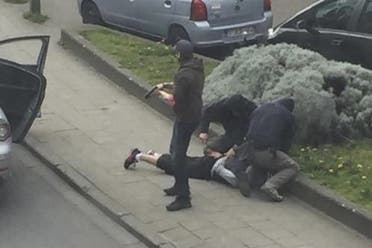 Police officers detain a suspect during a raid in which fugitive Mohamed Abrini was arrested in Anderlecht, near Brussels, Belgium, April 8, 2016 in this still image taken from video. REUTERS/Sebastien Dana-Kamran via Reuters 