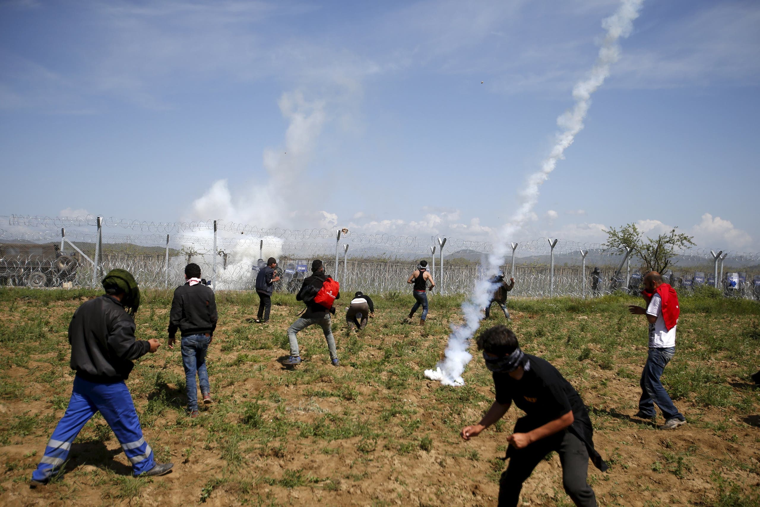 A teargas canister thrown by Macedonian police lands among protesting migrants during clashes next to a border fence at a makeshift camp for refugees and migrants at the Greek-Macedonian border near the village of Idomeni, Greece, April 10, 2016. (reuters)