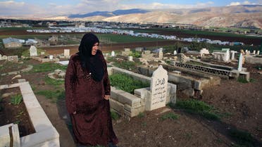 In this Tuesday, March 29, 2016 photo, Syrian refugee Saada Khalaf, 45, who fled from the city of Homs, Syria, walks in the cemetery in the eastern village of Dalhamyeh, in the Bekaa valley, Lebanon. (AP)