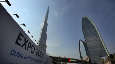In this Wednesday Nov. 20, 2013, with the Burj Khalifa, the world's tallest building in the background, vehicles pass by a billboard advertising Dubai as a candidate city for the Expo 2020 in Dubai, United Arab Emirates. (AP)