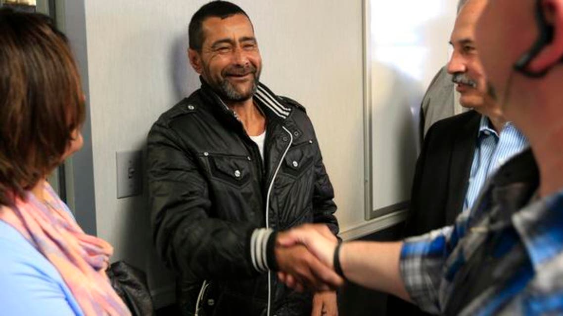 Ahmad al-Abboud, center, shakes hands with a reporter following a news conference at Della Lamb Community Services in Kansas City, Mo., Monday, April 11, 2016. Ahmad al-Abboud and his family are the first Syrian family to be resettled in the U.S. under a speeded-up "surge operation" for refugees. (AP)