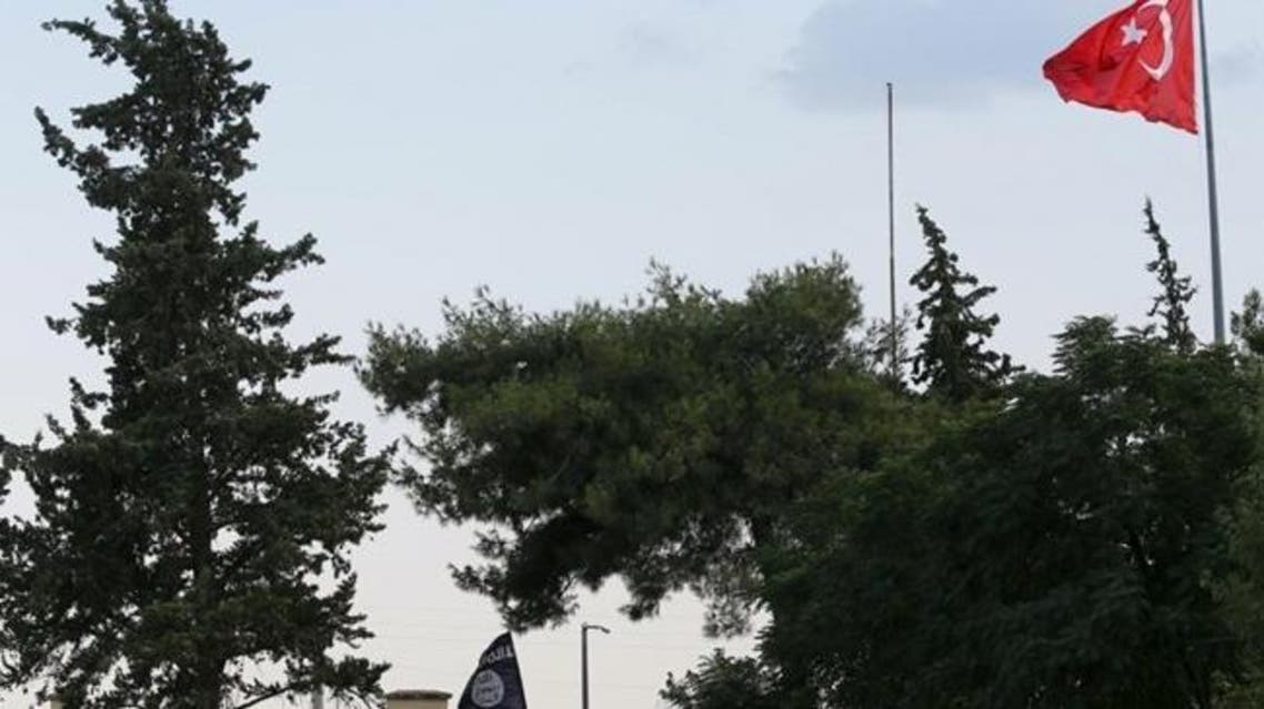 A Turkish flag flies over the Karkamis border crossing, with an ISIS flag is seen at the custom office of Syria's Jarablus border gate in the background, in Karkamis, in Gaziantep province, Turkey in this August 1, 2015 file photo. REUTERS/Murad Sezer/Files