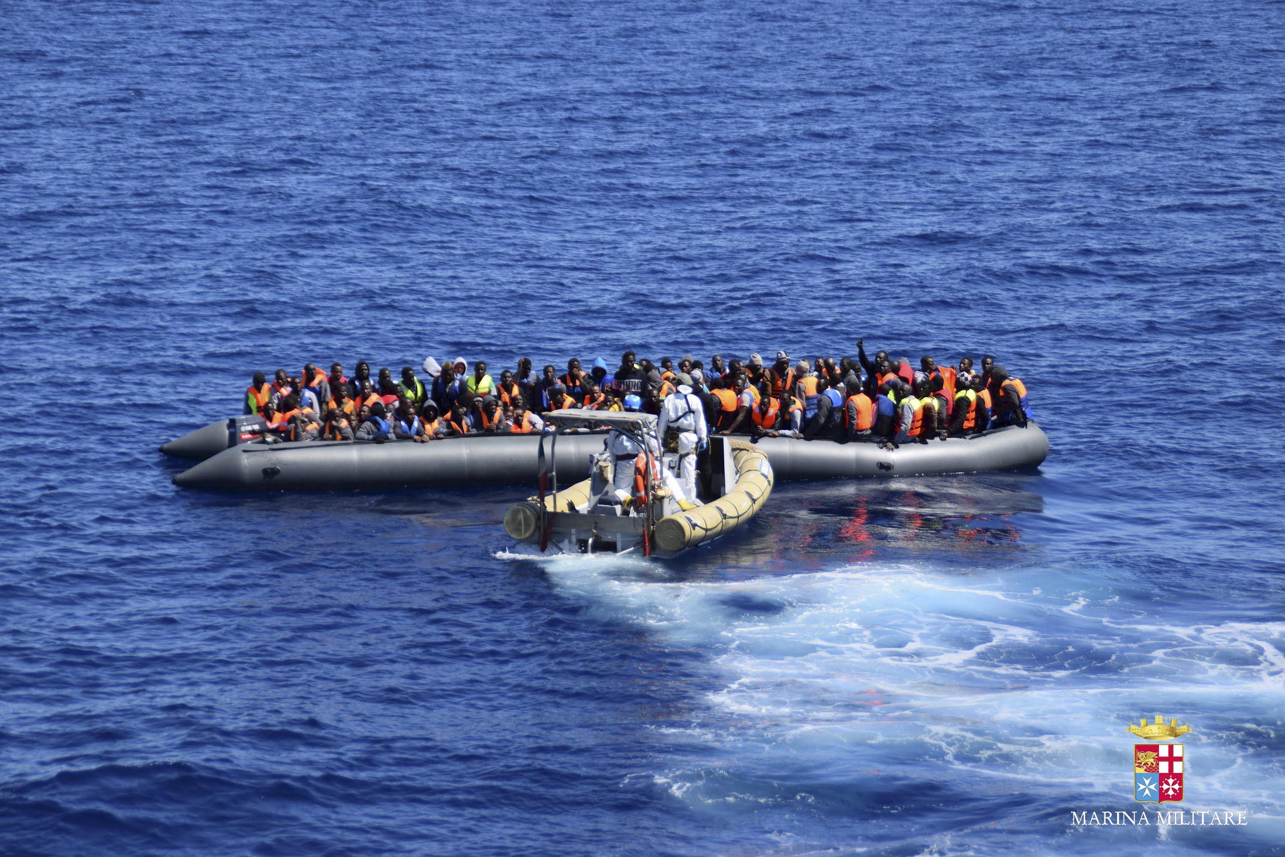 Migrants sit in their boat during a rescue operation by Italian Navy vessels off the coast of Sicily in this April 11, 2016 handout picture provided by Italy's Marina Militare. (Reuters)