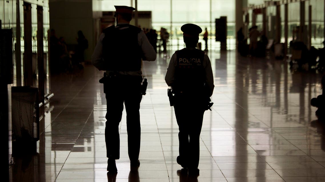 Police officers patrol inside a terminal of the airport during tighter security measures in Barcelona, Spain, Tuesday, March 22, 2016