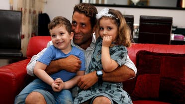 Noah and Lahela al-Amin pose for a picture with their father Ali Zeid al-Amin in their family home in Beirut, Lebanon. (Reuters)