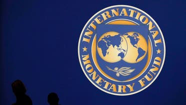 Visitors are silhouetted against the logo of the International Monetary Fund at the main venue for the IMF and World Bank annual meeting in Tokyo. (File photo: Reuters)