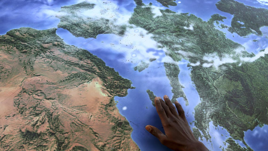 A migrant touches a globe shaped balloon during a rally held ahead of the start of the 2015 Paris World Climate Change Conference, known as the COP21 summit, in Rome, Italy , November 29, 2015. (Reuters)
