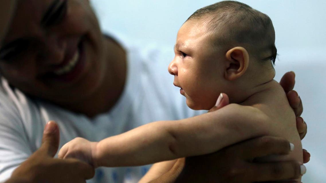 Therapist Rozely Fontoura holds Juan Pedro, who has microcephaly, in Recife, Brazil March 26, 2016. (Reuters)