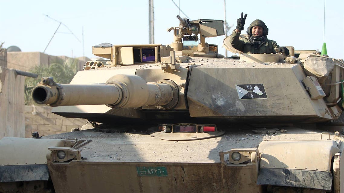 A member of Iraq's elite counter-terrorism service flashes the "V" for victory sign from inside a US-made Abrams tank. (AFP)