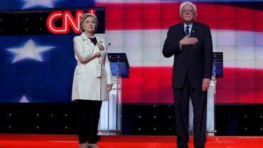 Democratic U.S. presidential candidates Clinton and Sanders hold their hands over their hearts before a Democratic debate hosted by CNN and New York One at the Brooklyn Navy Yard in New York. (Reuters)