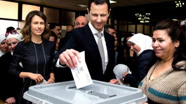 Syrian President Bashar Assad casting his ballot in the parliamentary elections, as his wife Asma, left, stands next to him, in Damascus, April 13, 2016. (AP)