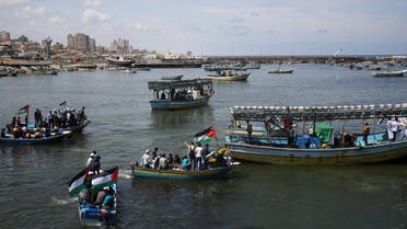 Palestinian youths wave national flags from boats during a protest organized by Palestinian activists against the Israeli naval blockade, at the fishermen’s port in Gaza City, Monday, May 19, 2014. (AP)