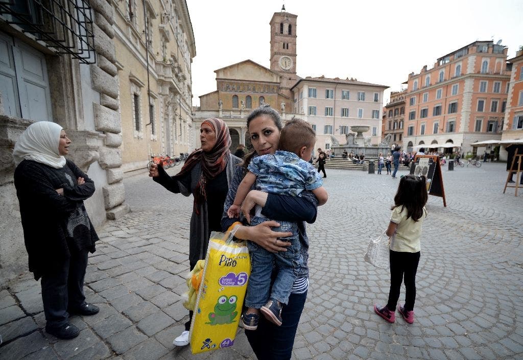 Nour, 30, a Syrian refugee and one of the 12 Syrian asylum seekers Pope Francis brought back with him from Greek island of Lesbos, holds her son Riad, 2, as she arrives at the St. Egidio Roman Catholic Charity in Rome on April 18, 2016 (AFP)