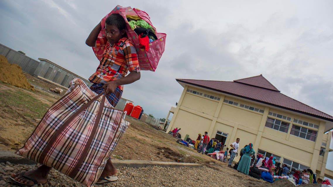 a Myanmar Rohingya man carrying his belongings to new temporary shelters for Rohingyas in Blang Adoe, North Aceh الروهينغا