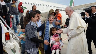 Pope Francis welcomes a group of Syrian refugees after landing at Ciampino airport in Rome following a visit at the Moria refugee camp on the Greek island of Lesbos on April 16, 2016 (AFP)