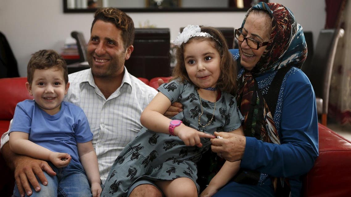 Noah (L) and Lahela al-Amin (2nd R) pose for a picture with their father Ali Zeid al-Amin (2nd L) and grandmother in their family home in Beirut, Lebanon April 8, 2016. Picture taken April 8, 2016. (Reuters)