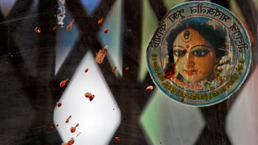 Blood stained glass and a photograph of the Hindu goddess Durga is seen near the spot where three motorcycle-riding assailants hacked student activist Nazimuddin Samad to death while walking with a friend, in Dhaka, Bangladesh, Thursday, April 7, 2016. 