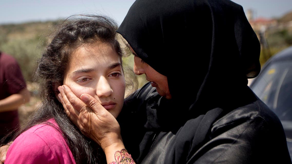 Sabha al-Wawi, right, Palestinian mother of 12-year-old Dima al-Wawi, imprisoned by Israel for allegedly attempting to carry out a stabbing attack, comforts her daughter, after her release from an Israeli prison, at Jabara checkpoint near the West Bank town of Tulkarem, Sunday, April 24, 2016. (AP)