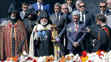 Armenian clergymen, US actor George Clooney, center, Armenian President Serzh Sargsyan, second right front, and guests attend a ceremony at a memorial to Armenians killed by the Ottoman Turks, in Yerevan, Armenia, on Sunday, April 24, 2016 (AP)