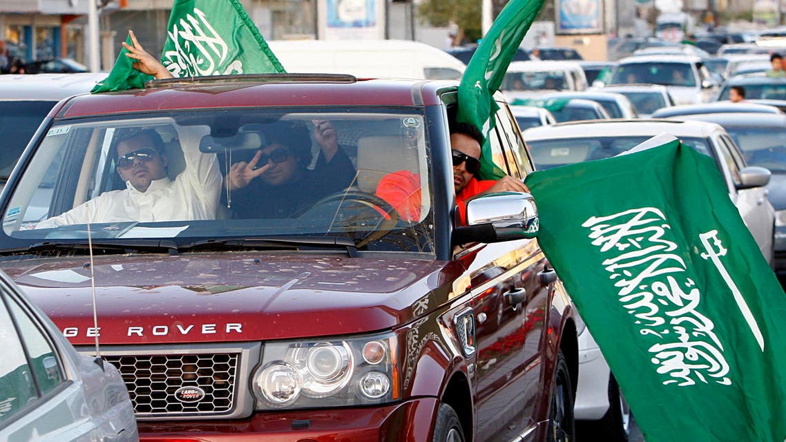 Saudi men gesture as they carry national flags during street celebrations in Riyadh, Saudi Arabia. (File photo AP)