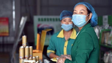 Workers serve samples of halal food products produced at the Sai Wai Xiang Halal Foodstuff Co in Qingtongxia, northern China's Ningxia province. (AFP)