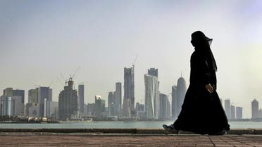 In this Friday, May 14, 2010 file photo, a Qatari woman walks in front of the city skyline in Doha. Qatar National Bank was responding to files circulating on social media that purport to show the personal information of hundreds of people, including staff at the broadcaster Al-Jazeera and members of the ruling family. (AP Photo/Kamran Jebreili)