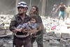 In this image made from video and posted online from Validated UGC, a Civil Defense worker carries a child after airstrikes hit Aleppo, Syria, Thursday, April 28, 2016. (AP)