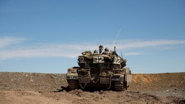 Israeli soldiers watch for their tank at the Druze village of Khader in Syria from the Israeli controlled Golan Heights, on the border with Syria, Thursday, Feb. 18, 2016. (AP Photo/Ariel Schalit)
