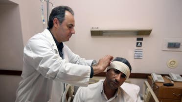An injured Iranian Mashallah Kahroudi, 44, who said that he works at Iranian embassy and who was wounded in the explosion receives treatment by Lebanese doctor Hussam Bitar at a hospital, in the suburb of Beir Hassan, Beirut, Lebanon, Wednesday, Feb. 19, 2014. (AP)