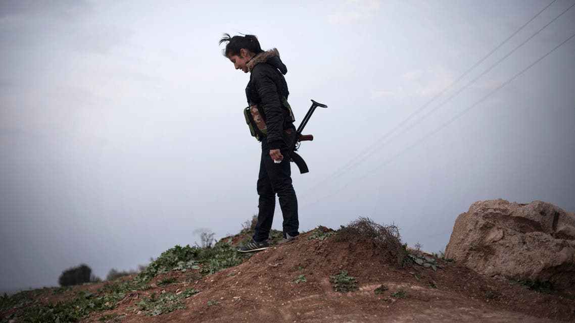 In this Sunday, March. 3, 2013 file photo, a Kurdish female member of the Popular Protection Units stands guard at a checkpoint near the northeastern city of Qamishli, Syria. AP