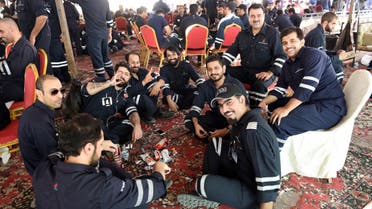 Kuwaiti oil sector employees sit in a shaded area on the first day of an official strike called by the Oil and Petrochemical Industries Workers Union over public sector pay reforms, in Ahmadi, Kuwait April 17, 2016. REUTERS