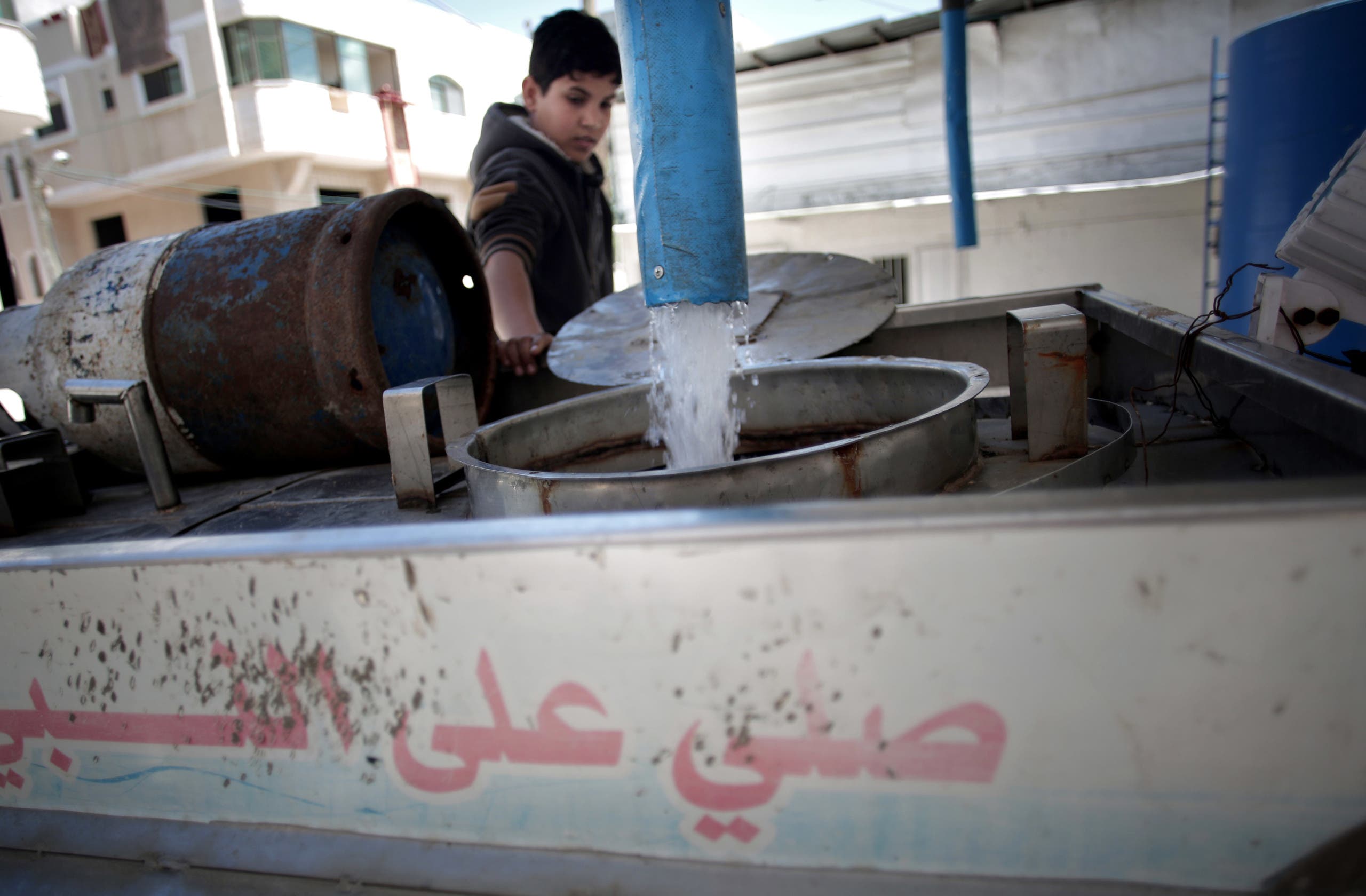 In this Thursday, April 14, 2016 photo, A Palestinian man fills tankers with drinking water for sale at a drinking water station in Gaza City. (AP)