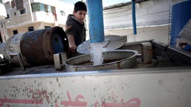 In this Thursday, April 14, 2016 photo, A Palestinian man fills tankers with drinking water for sale at a drinking water station in Gaza City. (AP)