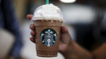 A woman holds a Frappuccino at a Starbucks store inside the Tom Bradley terminal at LAX airport in Los Angeles, California, United States, October 27, 2015. tarbucks Corp brewed up another quarter of strong sales and profit growth, but its shares fell more than 3 percent after the richly valued cafe chain's 2016 forecast offered little upside to Wall Street's target. Starbucks said on Thursday global sales at cafes open at least 13 months were up 8 percent in the fourth quarter ended Sept. 27, beating than the 6.9 percent rise expected by analysts polled by research firm Consensus Metrix. Picture taken October 27, 2015. REUTERS