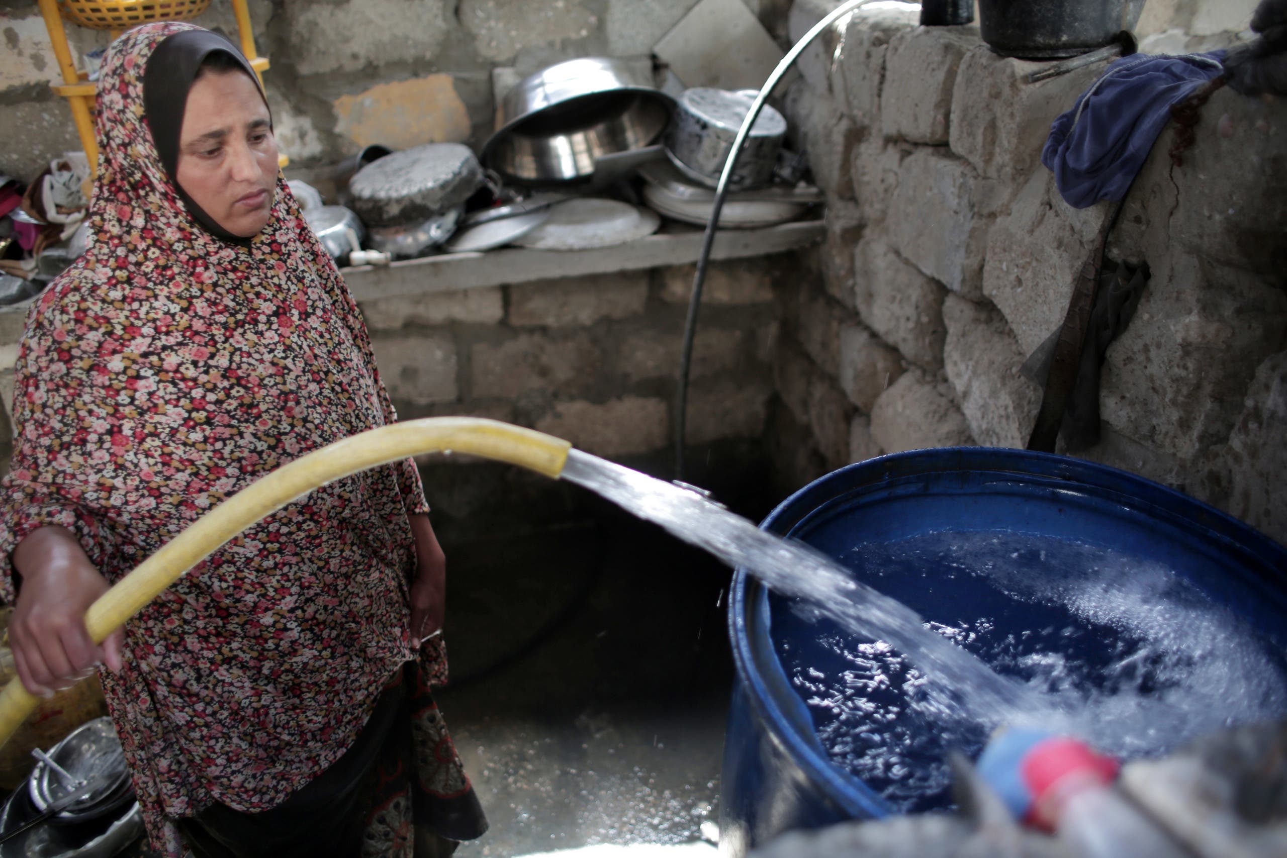 In this Saturday, April 16, 2016 photo, A Palestinian woman fills a water tank in her house with drinking water in Khan Younis refugee camp, southern Gaza Strip. 9AP)