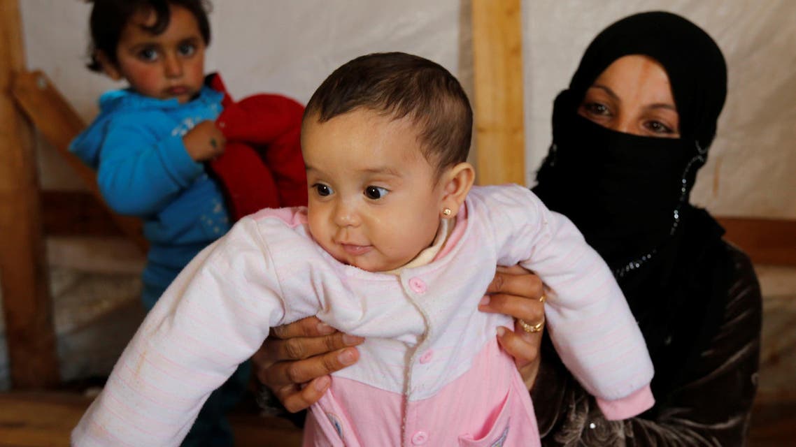 Syrian refugee Asheqa holds her unregistered baby daughter Nour inside a tent at a refugee camp near the town of Baalbek in LebanonÕs Bekaa valley, March 3, 2016. (Reuters)