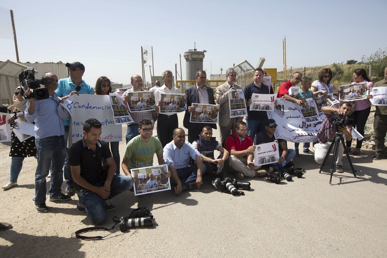 Palestinian journalists hold banners during a protest calling for the release of Palestinian journalist Omar Nazzal, who was arrested by Israeli authorities over the weekend, outside Ofer military prison near the West Bank city of Ramallah, Tuesday, April 26, 2016. (AP)