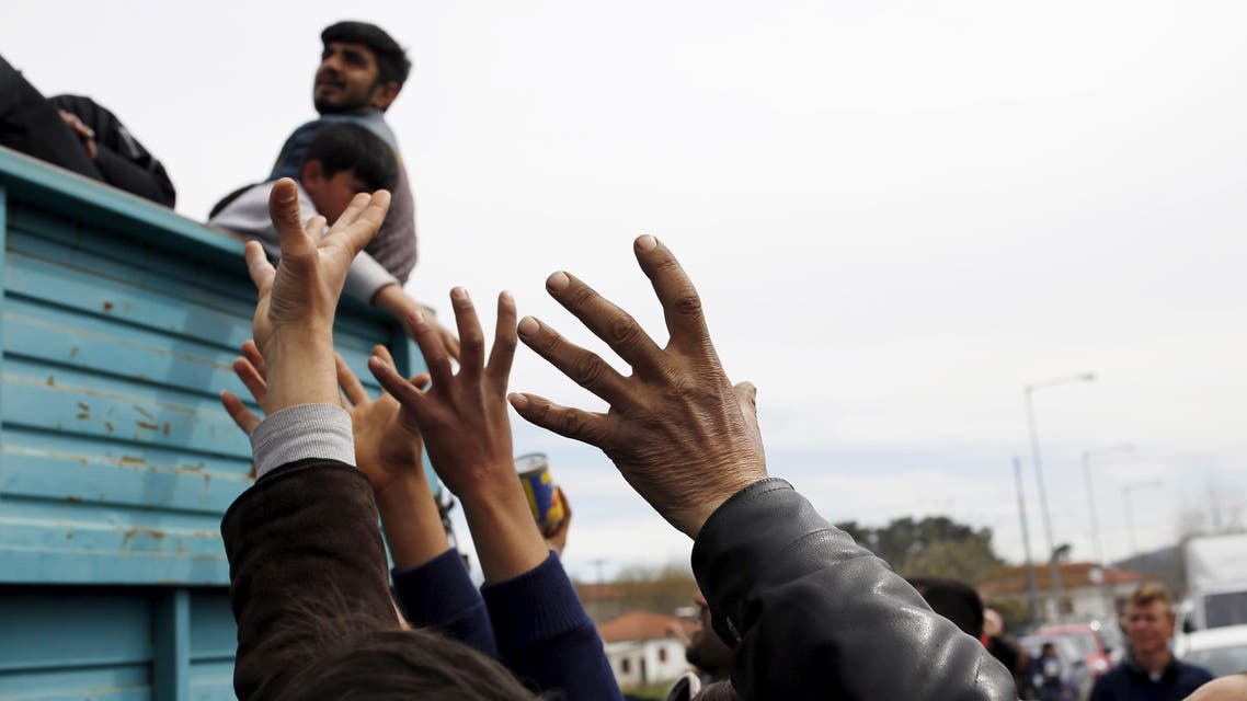 Migrants and refugees reach out to get humanitarian aid at a makeshift camp at the Greek-Macedonian border near the village of Idomeni, Greece, March 26, 2016. (Reuters)