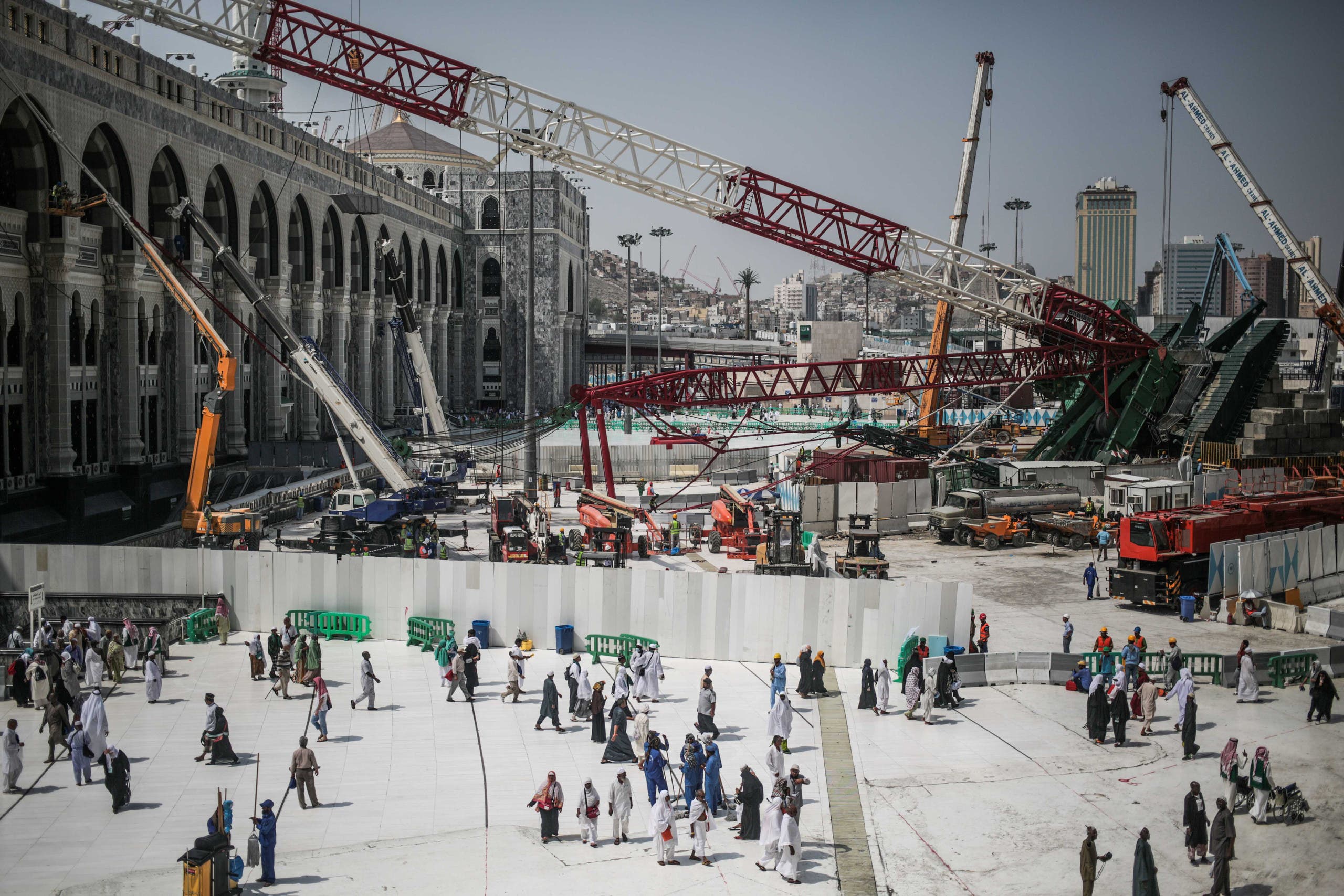 In this Tuesday, Sept. 15, 2015 file photo, Muslim Pilgrims walk past the site of a crane collapse that killed over a hundred Friday at the Grand Mosque in the holy city of Makkah, Saudi Arabia. (AP)