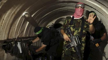 A Palestinian fighter from the Izz el-Deen al-Qassam Brigades, the armed wing of the Hamas movement, gestures inside an underground tunnel in Gaza (Reuters)