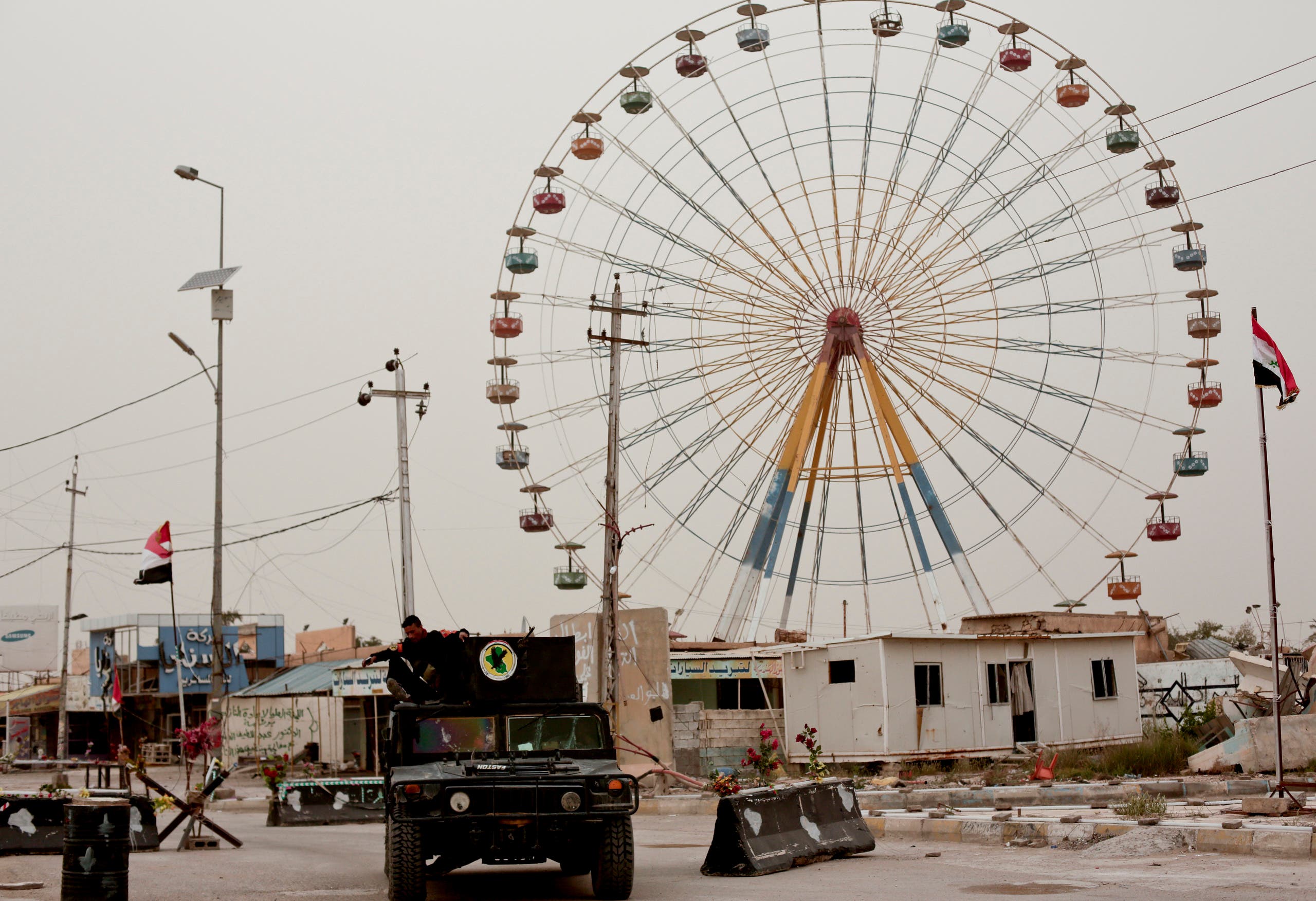 Iraqi counterterrorism forces drive past a ferris wheel in a central district of Ramadi on March 20, 2016. AP