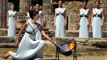 Greek actress Katerina Lehou , playing the role of High Priestess, lights a torch from the sun's rays reflected in a parabolic mirror during the dress rehearsal for the Olympic flame lighting ceremony for the Rio 2016 Olympic Games at the site of ancient Olympia in Greece, April 20, 2016. (Reuters)