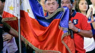  Philippine presidential race front-runner Davao city mayor Rodrigo Duterte kisses the Philippine flag during his final campaign rally in Manila, Philippines on Saturday, May 7, 2016. A bruising presidential campaign drew to a close in the Philippines Saturday with a last-minute attempt by the president to unify candidates against a front running mayor perceived as a threat to democracy virtually collapsing. (AP Photo/Aaron Favila)