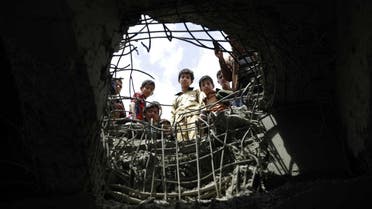 Boys look through a hole made by a Saudi-led airstrike on a bridge in Sanaa, Yemen, Wednesday, March 23, 2016. Yemen has been left fragmented by war pitting Shiite Houthi rebels and military units loyal to a former president against a U.S.-backed, Saudi-led coalition supporting the internationally recognized government. (AP Photo/Hani Mohammed)