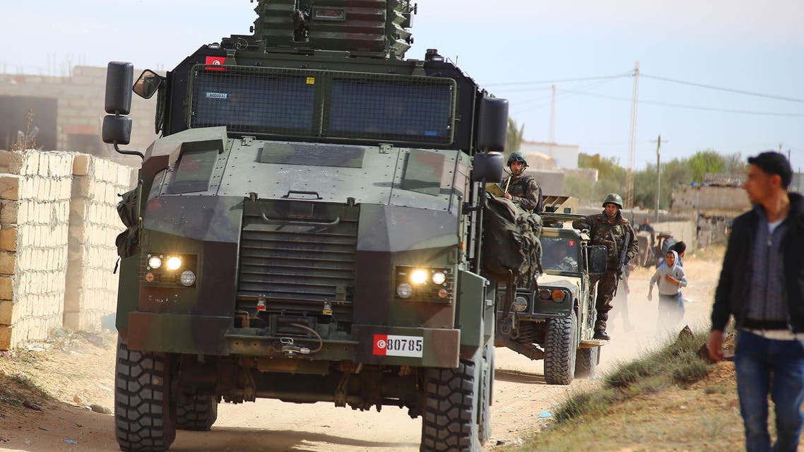 Tunisian soldiers ride armored vehicles as they search for attackers still at large in the outskirts of Ben Guerdane, southern Tunisia, Tuesday, March 8, 2016. (AP Photo)