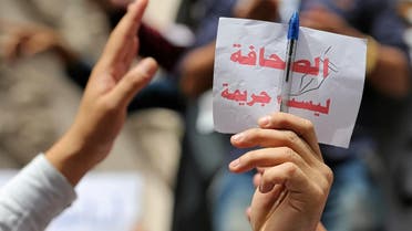 Journalist holds up a sign, which reads: ''Journalism is not a crime'', during a protest against restrictions on the press and to demand the release of detained journalists, in front of the Press Syndicate in Cairo. (File photo: Reuters)