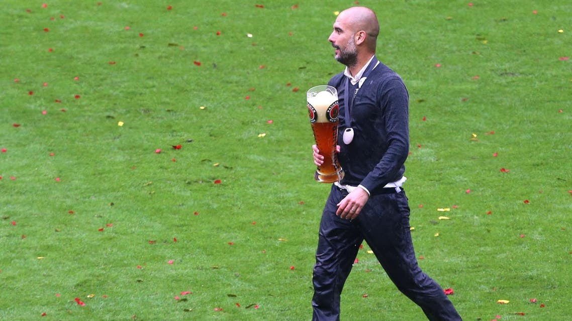 Munich coach Pep Guardiola walks with a beer mug as Bayern Munich's soccer team celebrates the German Championships during celebrations in the stadium in Munich, Germany, Saturday May 14, 2016. (Karl-Josef Hildenbrand/dpa via AP)