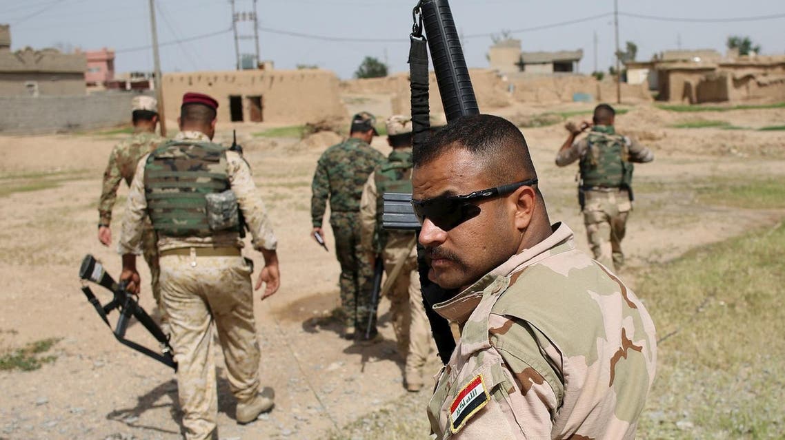 Iraqi soldier holds up his rifle as he walks with other soldiers in a village of Mahana some 60 km south of Mosul, Iraq, April 28, 2016. REUTERS