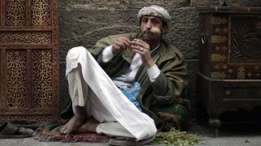 A Yemeni carpenter sits outside his shop as he chews qat, a mildly narcotic plant, in the old city of Sanaa, Yemen, Saturday, Dec. 31, 2011. (AP 